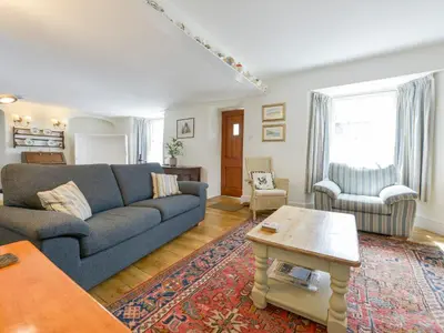 a living room with a blue couch and a table at Agar Cottage in Port Isaac