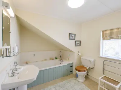 a bathroom with a sink and a toilet and a bath tub at Agar Cottage in Port Isaac