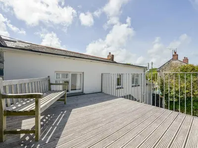 a wooden deck with a bench on top of a building at Agar Cottage in Port Isaac