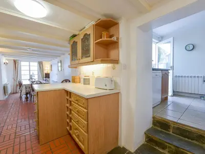 a kitchen with wooden cabinets and a counter top at Agar Cottage in Port Isaac