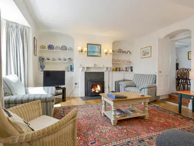 a living room with couches and a fireplace at Agar Cottage in Port Isaac