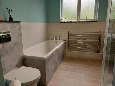 a bathroom with a bath tub and a toilet at Heightley House in Tintagel