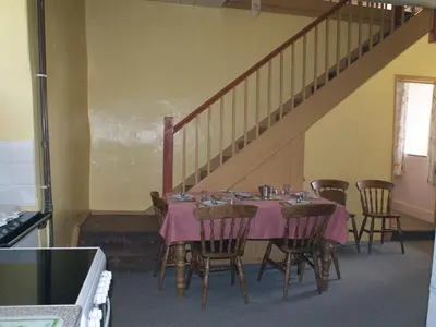 a dining room with a table with chairs and a staircase at Tresungers Cottage in Port Isaac