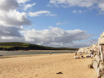 a group of people sitting on a sandy beach at Tresungers Cottage in Port Isaac