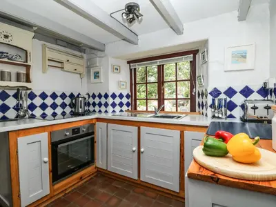 a kitchen with a counter with a bowl of vegetables on a cutting board at Uphill Cottage in Saint Ervan