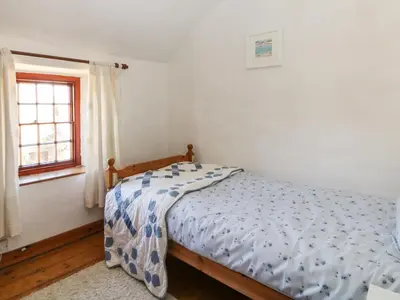 a bedroom with a bed and a window at Uphill Cottage in Saint Ervan