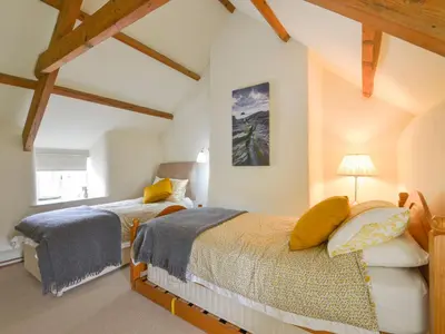 two beds in a attic bedroom with wooden beams at 3 Newhall Green in Delabole