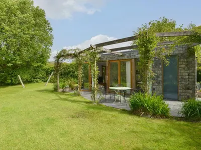 a home with a patio and a table in the yard at 3 Newhall Green in Delabole