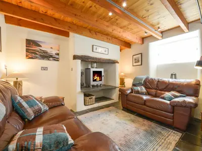 a living room with leather furniture and a fireplace at 3 Newhall Green in Delabole