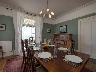 a dining room with a wooden table and chairs at The Captains House in Downderry