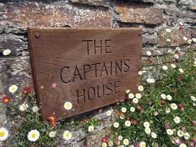 a sign that says the captains house on a wall at The Captains House in Downderry