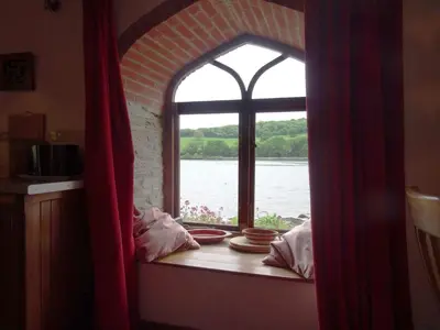 a window in a room with a view of the water at The Boat House in Lerryn