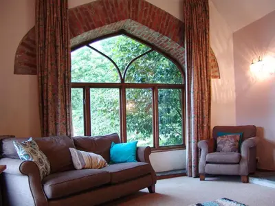 a living room with a couch and a large window at The Boat House in Lerryn