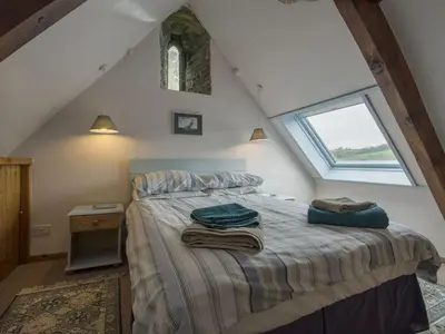 a bedroom with a bed with towels on it at The Boat House in Lerryn