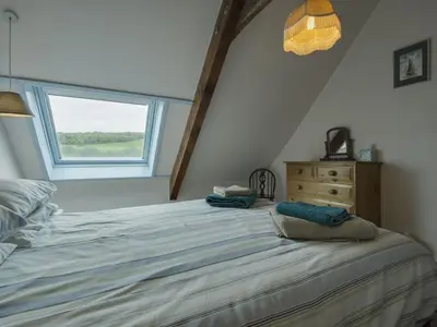 a bedroom with a bed with a window and a dresser at The Boat House in Lerryn