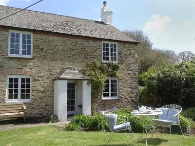a stone house with a table and chairs in front of it at Kingbarth in Lerryn