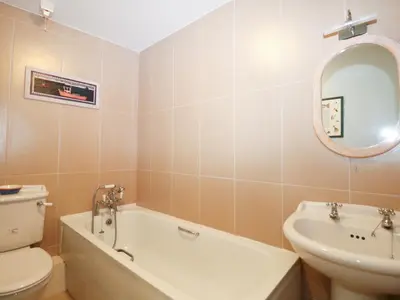 a bathroom with a tub and a toilet and a sink at Pier Cottage in Saint Mawes