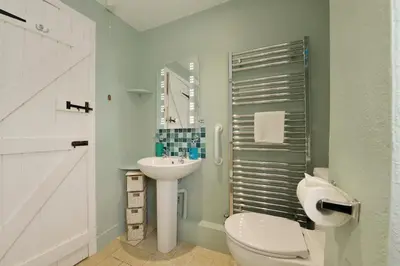 a bathroom with a white toilet and a sink at Regatta Cottage in Feock