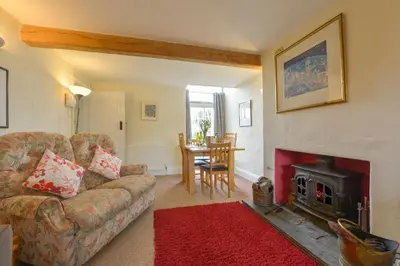 a living room with a couch and a fireplace at Regatta Cottage in Feock