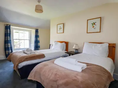 a bedroom with two beds with towels on them at Polcreek Farmhouse in Veryan