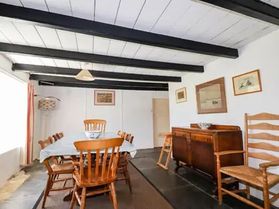 a dining room with a table and chairs at Polcreek Farmhouse in Veryan