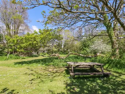 a picnic table in the grass under a tree at Polcreek Farmhouse in Veryan