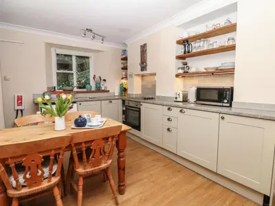 a kitchen with a wooden table and a dining room at Quarry Cottage in Flushing