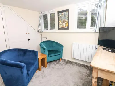 a living room with two chairs and a television at Quarry Cottage in Flushing