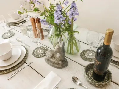 a table with a bottle of wine and a vase of flowers at Evergreen in Breage