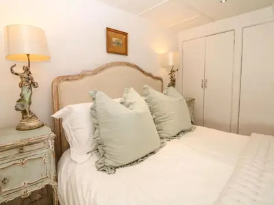 a bedroom with a white bed with white pillows at Evergreen in Breage