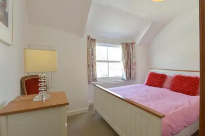a bedroom with a bed and a window at April Cottage in Coverack