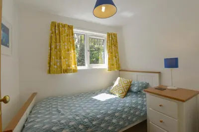 a small bedroom with a bed and a window at April Cottage in Coverack