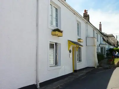 a row of white houses on a street at April Cottage in Coverack