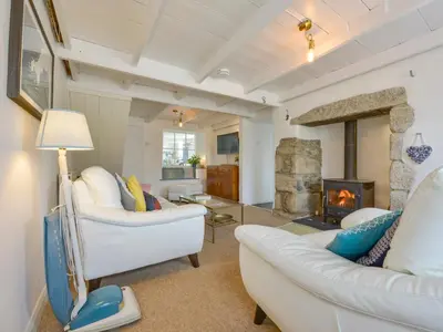 a living room with two white couches and a fireplace at 2 Trerise Cottage in Helford