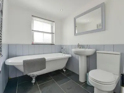a bathroom with a tub and a toilet and a sink at 2 Trerise Cottage in Helford