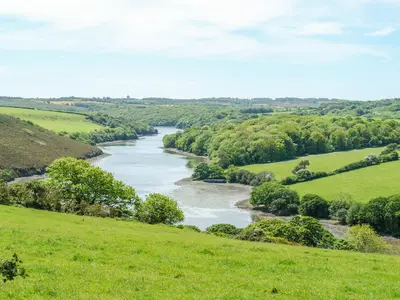 a river in the middle of a green field at 2 Trerise Cottage in Helford