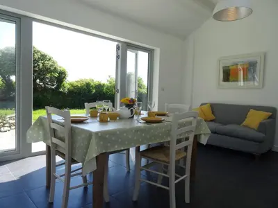 a dining room with a table and chairs and a couch at The Studio in Germoe