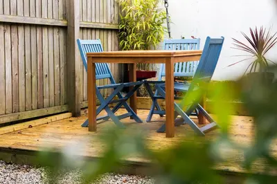 two blue chairs and a wooden table on a patio at The cabin in Truro