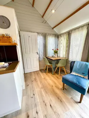 a living room with a blue chair and a table at The cabin in Truro