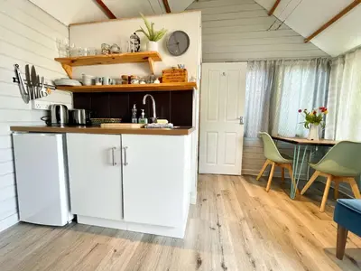 a kitchen with white cabinets and a table at The cabin in Truro
