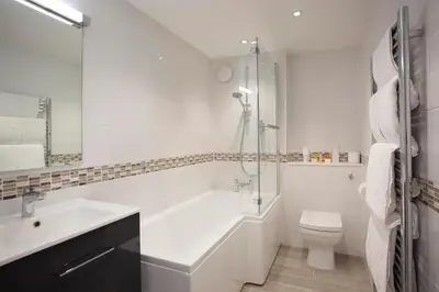 a white bathroom with a sink and a toilet at Falmouth Self Catering Lodges in Falmouth