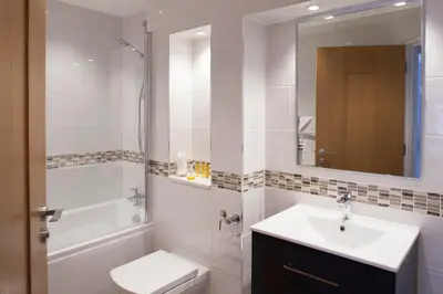 a bathroom with a sink and a toilet and a shower at Falmouth Self Catering Lodges in Falmouth