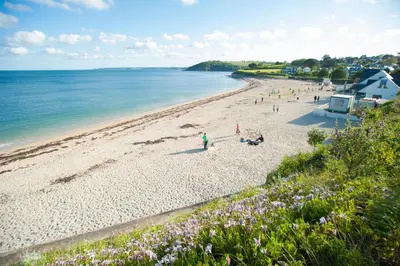 a group of people on a beach near the water at Falmouth Self Catering Lodges in Falmouth