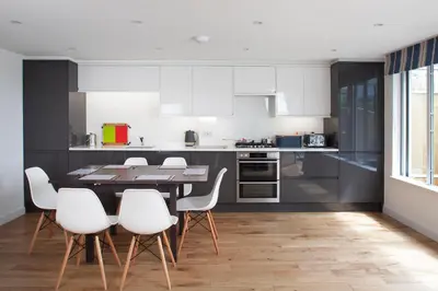 a kitchen with a dining table and white chairs at Falmouth Self Catering Lodges in Falmouth