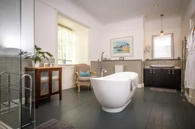 a large bathroom with a tub and a sink at Trewornan Manor in Wadebridge