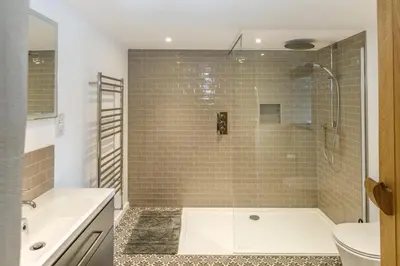 a bathroom with a shower and a tub and a sink at Trewornan Manor in Wadebridge