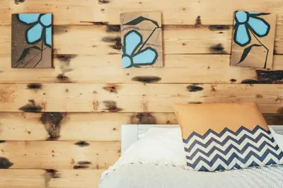 a bedroom with a wooden wall with pictures on it at Storm in a tea cup in St Ives