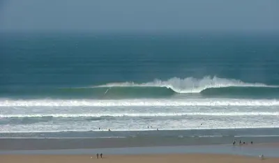 a group of people in the ocean with waves at Waves Apartments in Newquay