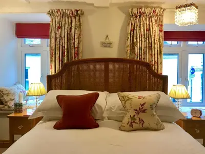 a bedroom with a bed with white sheets and pillows at Cyntwell Guest Accommodation in Padstow