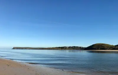 a view of a beach with a hill in the distance at Cyntwell Guest Accommodation in Padstow